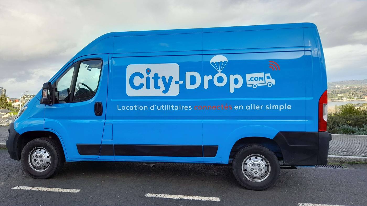 Utilitaire City Drop 12 m³ garé sur un parking en bord de mer